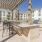 a patio with tables and chairs and a building in the background